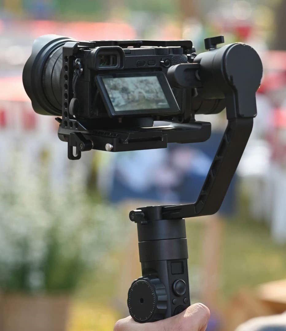 An image of a professional camera mounted on a handheld gimbal stabilizer, designed for smooth video recording and photography.